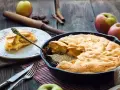 Torta di mele in padella in 10 minuti: soffice e dorata, pronta per essere gustata. Una fetta invitante su un piatto bianco.