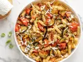Pasta fredda con melanzane, pomodori e ricotta salata grattugiata. Un'idea perfetta per cosa mettere nella pasta fredda, fresca e saporita.