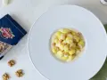 Gnocchi al Castelmagno con noci croccanti, un piatto cremoso e saporito. La confezione di noci Ventura accanto promette un tocco di gusto in più.
