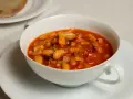 Fagioli in umido, una ricetta veneta saporita con fagioli bianchi, pancetta e pomodoro, serviti in una ciotola bianca.