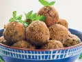 Polpette dorate e croccanti, perfette per le tue ricette con melanzane. Guarnite con prezzemolo e basilico fresco.