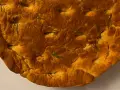 Focaccia di lenticchie dorata e fragrante, con rosmarino fresco che spunta dalla crosta croccante.