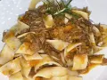 Pappardelle condite con un saporito ragù di cinghiale in bianco, guarnite con rosmarino fresco.