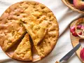 Una deliziosa torta di mele con farina di avena, appena sfornata, con mele fresche e scorze su un tagliere.