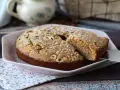Deliziosa torta di nocciole senza farina, cosparsa di zucchero a velo e nocciole intere. Perfetta per ogni occasione.