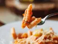 Forchetta con penne al pomodoro, un esempio di sughi per pasta veloci e leggeri.