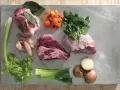 Ingredienti per un brodo saporito: carne per brodo, carote, sedano, cipolle, prezzemolo e alloro.