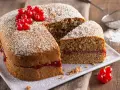 Torta di grano saraceno soffice, farcita con marmellata e decorata con ribes rossi e zucchero a velo.