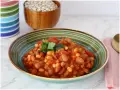 Un piatto invitante di fagioli in umido, con pomodoro e prezzemolo fresco, pronto per essere gustato.