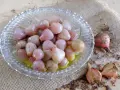 Lampascioni, piccoli bulbi rosa in una ciotola di vetro, sono un sapore pugliese da scoprire.