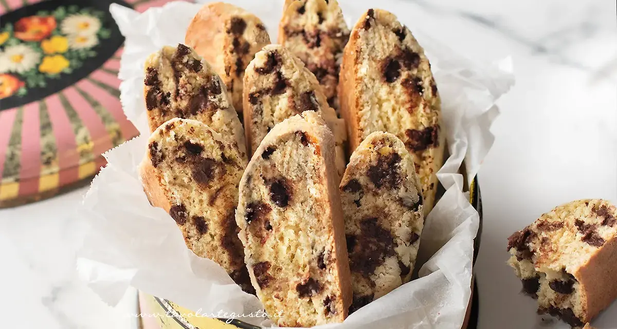 Biscotti con frutta secca, croccanti e golosi, serviti in un contenitore vintage. Perfetti per la colazione o una pausa caffè.