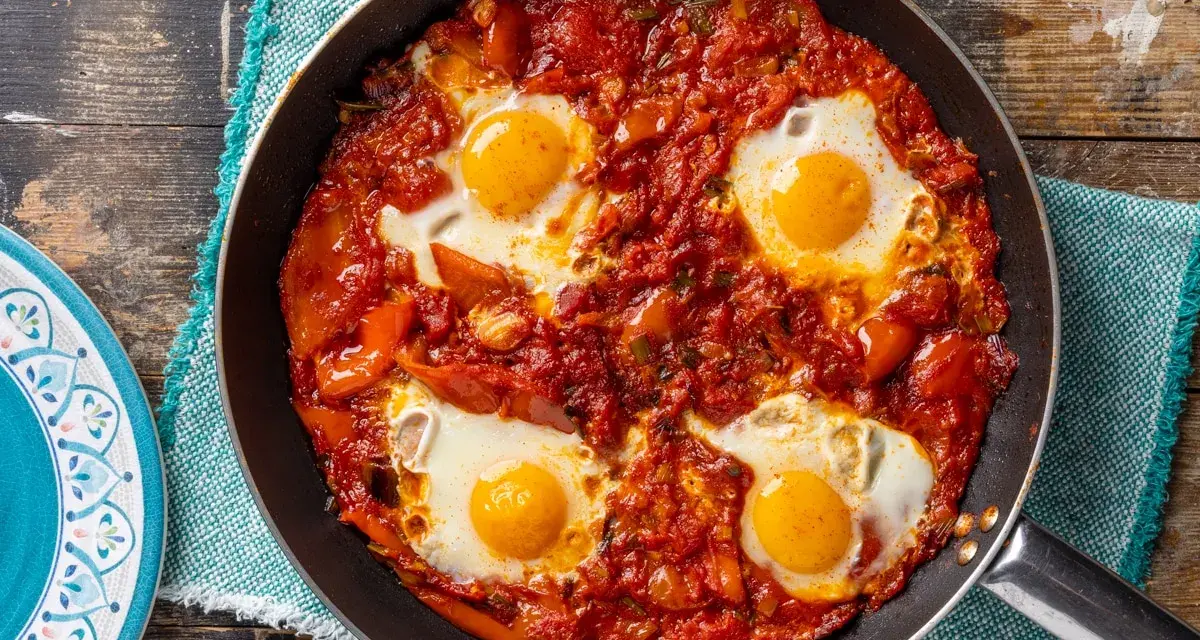 Uova in purgatorio in padella, un classico tra le ricette con uova, con pomodoro e peperoni.