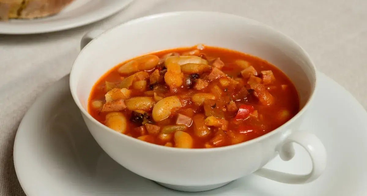 Fagioli in umido, una ricetta veneta saporita con fagioli bianchi, pancetta e pomodoro, serviti in una ciotola bianca.