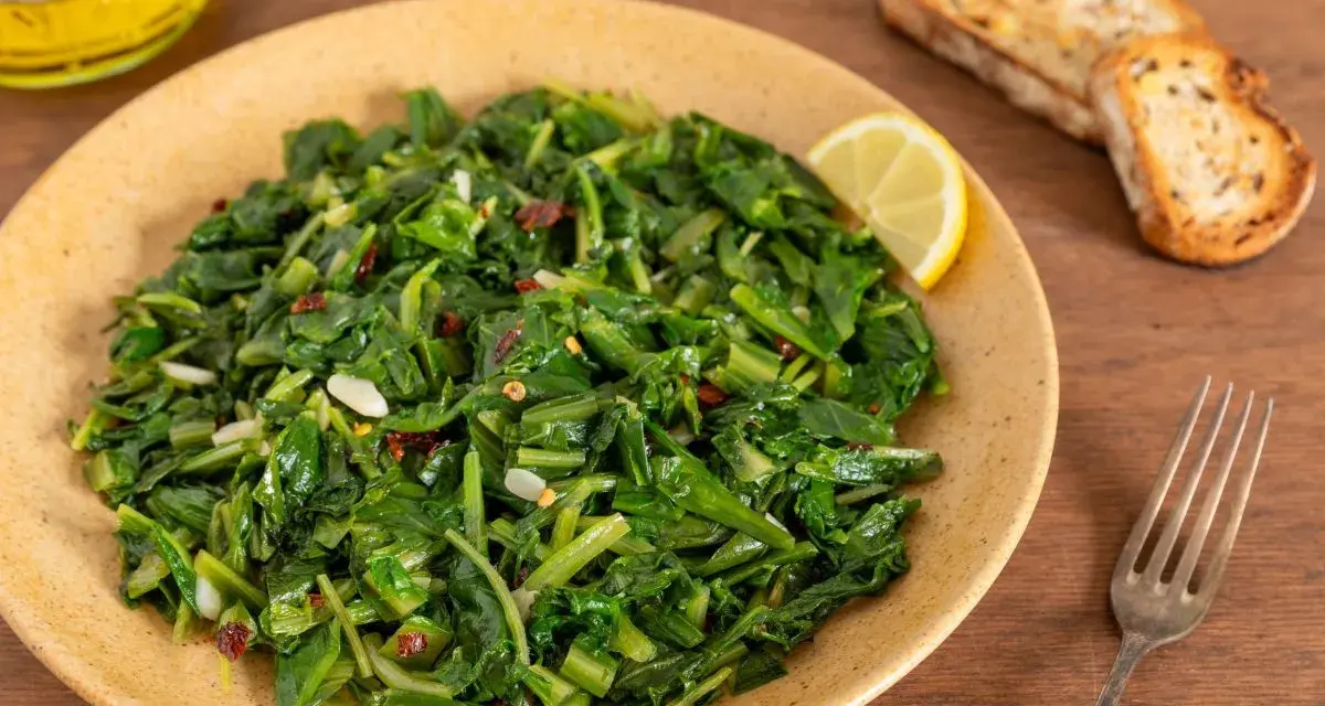 Cicoria saltata con aglio e peperoncino, un modo semplice per imparare come cucinare la cicoria. Servita con pane tostato e limone.