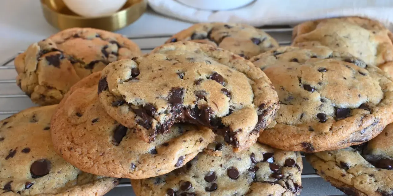 Biscotti cookies al cioccolato, appena sfornati e ancora caldi, con gocce di cioccolato fondente che si sciolgono. Una ricetta perfetta per una pausa golosa.