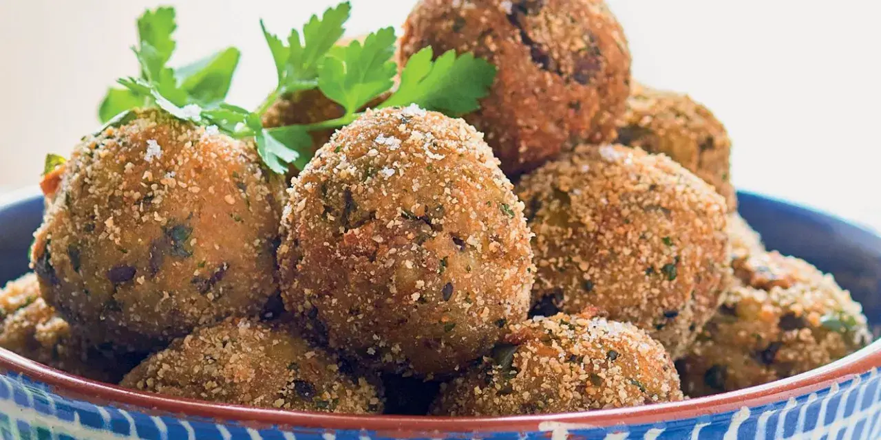 Polpette dorate e croccanti, perfette per le tue ricette con melanzane. Guarnite con prezzemolo e basilico fresco.