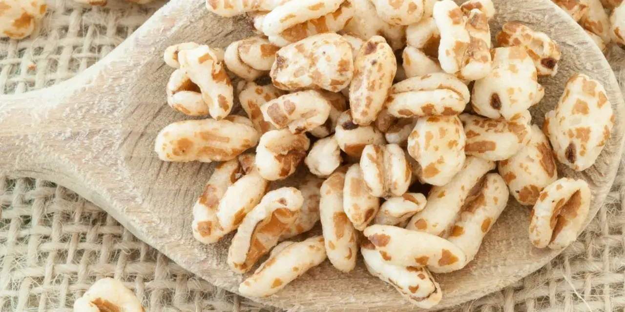 Farro soffiato su un cucchiaio di legno, perfetto per colazioni leggere e ricette creative.