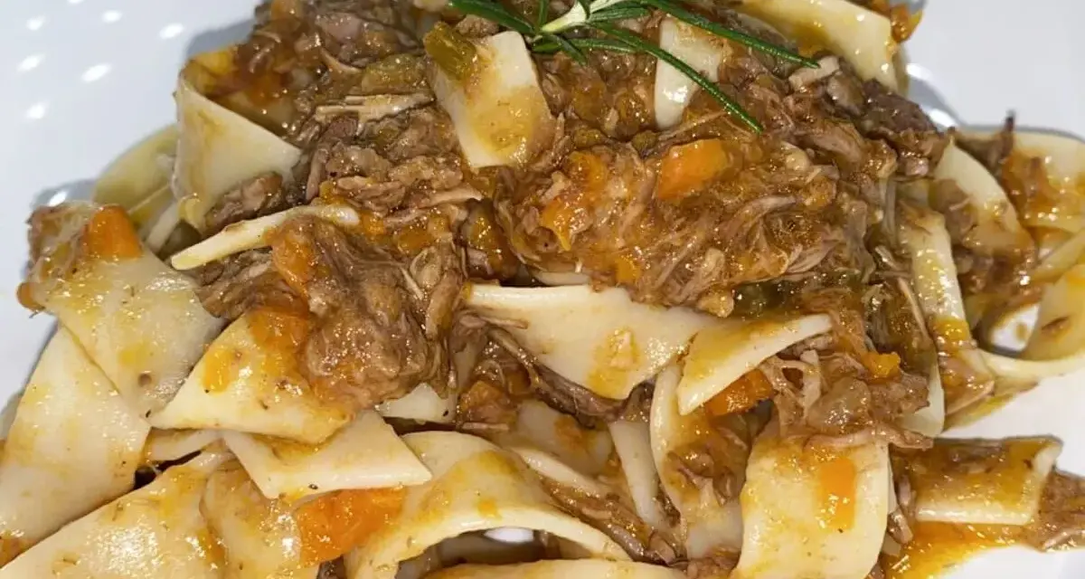 Pappardelle condite con un saporito ragù di cinghiale in bianco, guarnite con rosmarino fresco.
