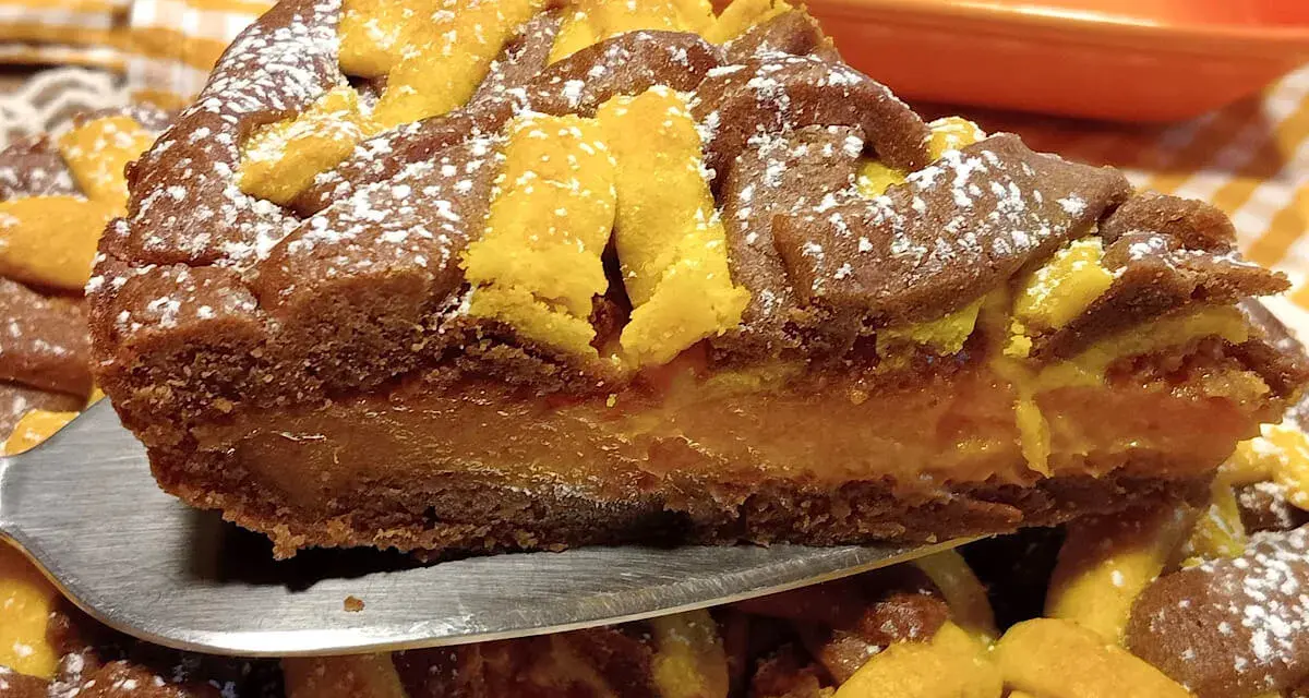 Fetta di torta con ripieno cremoso e decorazioni a griglia, uno dei tanti dolci con albicocche che invitano ad essere assaggiati.