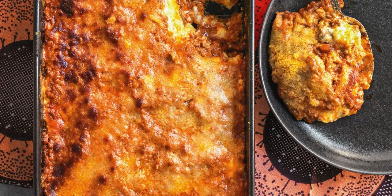Una porzione di lasagna al ragù appena sfornata, dorata e invitante, pronta per essere gustata.
