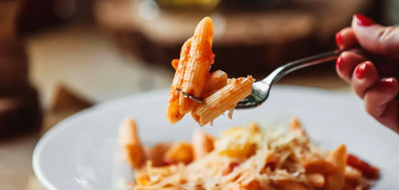 Forchetta con penne al pomodoro, un esempio di sughi per pasta veloci e leggeri.