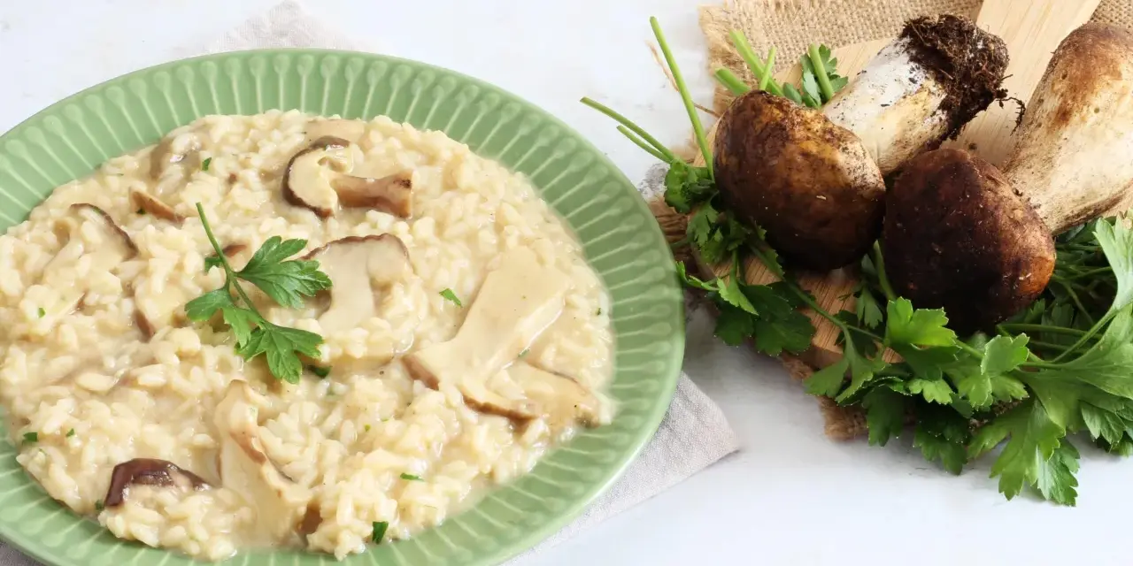 Piatto di cremoso risotto ai funghi, con funghi freschi e prezzemolo a guarnire. Un'ottima alternativa al risotto ai funghi surgelati.
