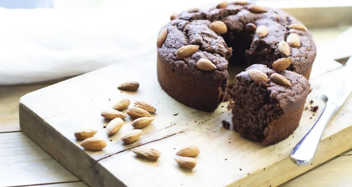 Torta al cioccolato con mandorle, una deliziosa torta con cereali avanzati, su tagliere di legno.
