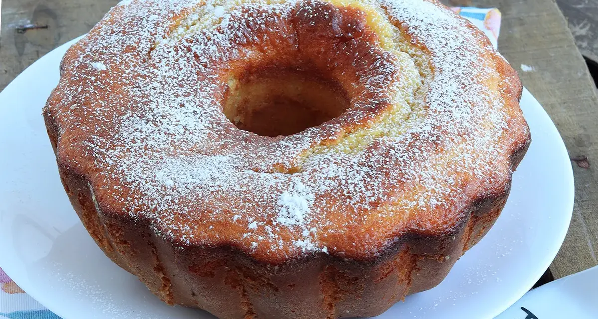 Ciambella soffice allo yogurt greco, cosparsa di zucchero a velo, pronta per essere gustata.