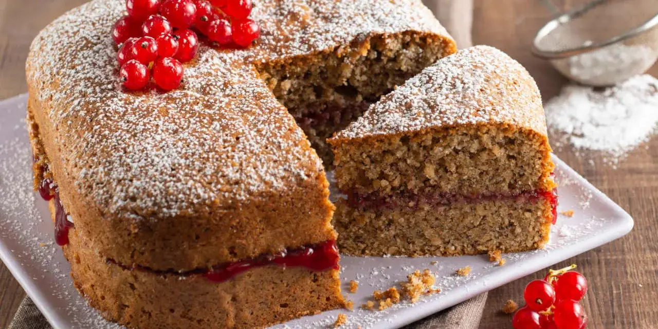 Torta di grano saraceno soffice, farcita con marmellata e decorata con ribes rossi e zucchero a velo.