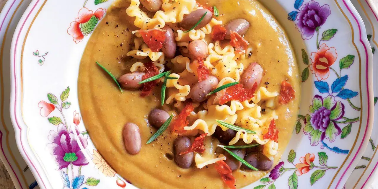 Un piatto invitante di pasta e fagioli, con pasta riccia, fagioli borlotti, pomodori secchi e rosmarino. La ricetta originale è un classico confortante.