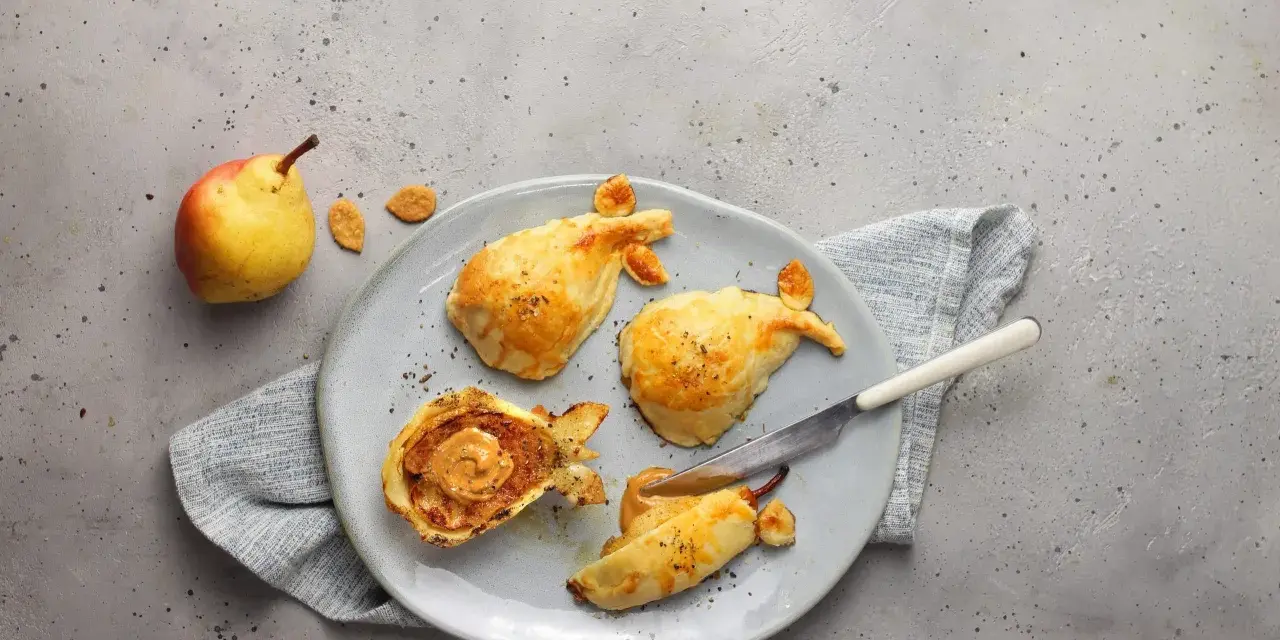 Pasticcini salati a forma di pesce, uno aperto rivela un ripieno cremoso. Un'idea originale per le tue ricette con le pere.