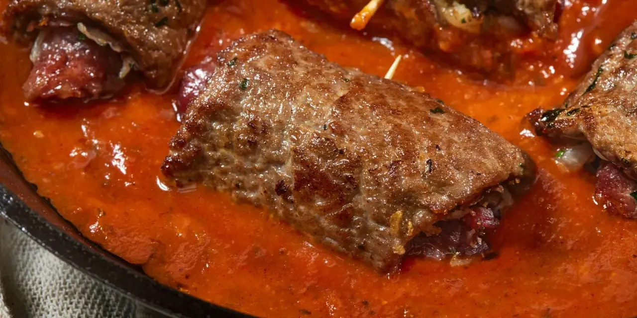 Involtini di carne in padella con sughetto rosso, un piatto succulento e invitante.