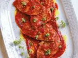 Bistecche alla pizzaiola succulente, ricoperte da salsa rossa e guarnite con erbe aromatiche fresche.