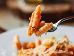 Forchetta con penne al pomodoro, un esempio di sughi per pasta veloci e leggeri.