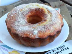 Ciambella soffice allo yogurt greco, cosparsa di zucchero a velo, pronta per essere gustata.