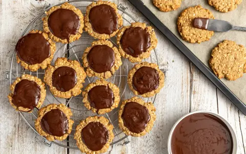 Deliziosi dolci con fiocchi di avena, alcuni ricoperti di cioccolato fuso, pronti per essere gustati.