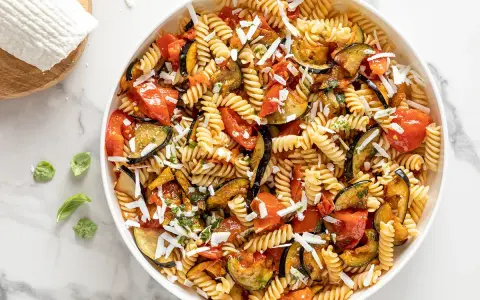 Pasta fredda con melanzane, pomodori e ricotta salata grattugiata. Un'idea perfetta per cosa mettere nella pasta fredda, fresca e saporita.