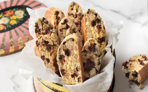 Biscotti con frutta secca, croccanti e golosi, serviti in un contenitore vintage. Perfetti per la colazione o una pausa caffè.