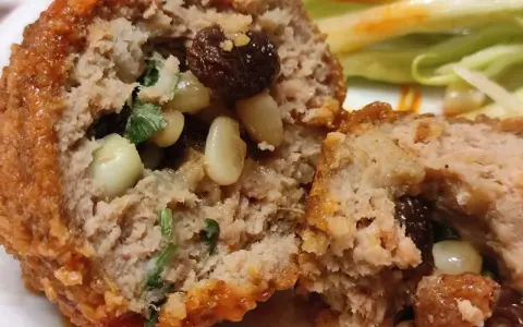 Polpette al sugo napoletane, un abbraccio di carne saporita con pinoli e uvetta, immerse in un sugo rosso invitante.
