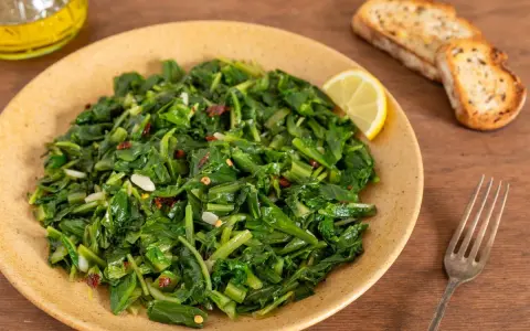 Cicoria saltata con aglio e peperoncino, un modo semplice per imparare come cucinare la cicoria. Servita con pane tostato e limone.