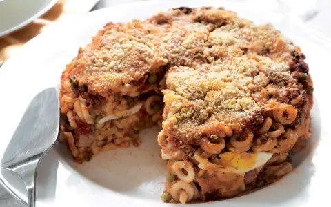 Un invitante anelletti al forno, dorato e croccante, con strati di pasta, ragù, piselli e uova sode.