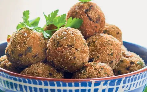Polpette dorate e croccanti, perfette per le tue ricette con melanzane. Guarnite con prezzemolo e basilico fresco.
