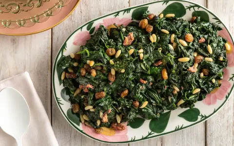 Spinaci saltati con pinoli e uvetta, un modo gustoso per imparare come cucinare gli spinaci.