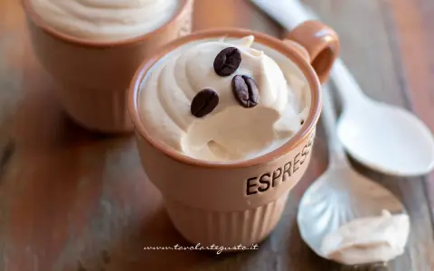 Deliziosa crema al caffè in tazzine, guarnita con chicchi di caffè. Perfetta per una pausa golosa.