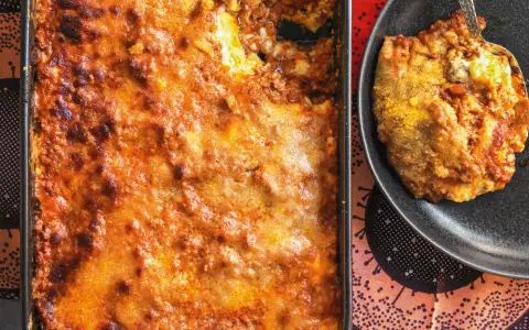 Una porzione di lasagna al ragù appena sfornata, dorata e invitante, pronta per essere gustata.