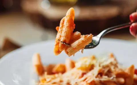 Forchetta con penne al pomodoro, un esempio di sughi per pasta veloci e leggeri.