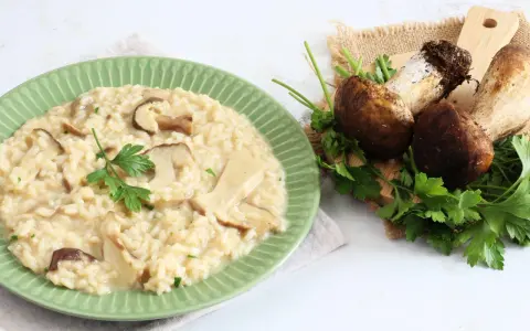 Piatto di cremoso risotto ai funghi, con funghi freschi e prezzemolo a guarnire. Un'ottima alternativa al risotto ai funghi surgelati.