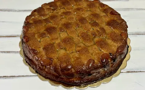 Deliziosa torta di mandorle siciliana, con una crosta dorata e mandorle intere a decorare il bordo.