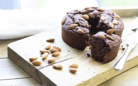Torta al cioccolato con mandorle, una deliziosa torta con cereali avanzati, su tagliere di legno.