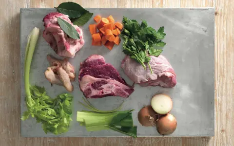 Ingredienti per un brodo saporito: carne per brodo, carote, sedano, cipolle, prezzemolo e alloro.
